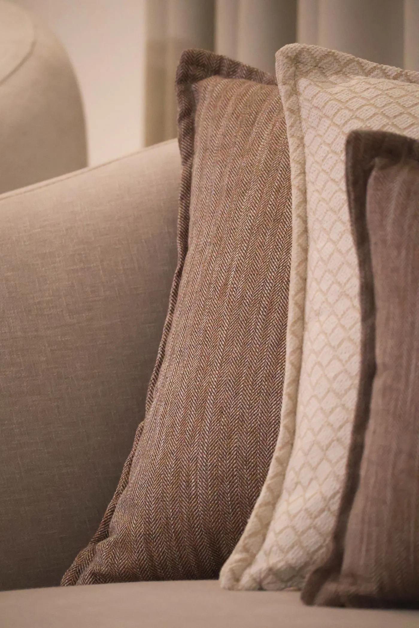 Kuddar i beige och brunt på en soffa